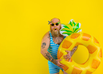 Fat amazed man with wig in head is ready to swim with a donut lifesaver