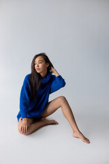 Attractive asian woman in blue sweater on white background. Model tests.