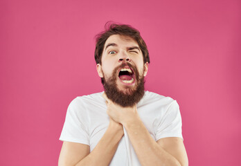 emotional man in white t-shirt studio pink background