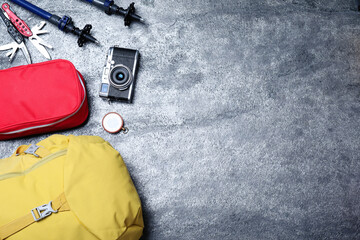 Flat lay composition with tourist backpack and other different camping equipment on grey background, space for text
