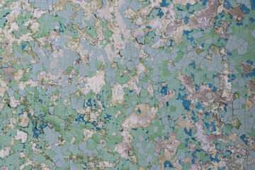 Peeling paint on the wall. Old concrete wall with cracked flaking paint. Weathered rough painted surface with patterns of cracks and peeling. High resolution texture for background and design. Closeup