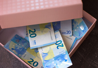 European money banknotes of twenty euros in a pink box, the theme of savings and personal finance savings, selective focus