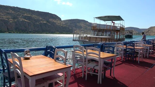 Halfeti, Sanliurfa, Turkey - 14th of June 2021: 4K Empty trip boat puts away from quay restaurant in Halfeti
