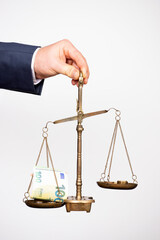 Money weighing on justice scale in business man hand. Payment balance and tax