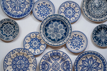 Traditional Hungarian porcelain handmade in blue paint on a white wall at a street market, village...