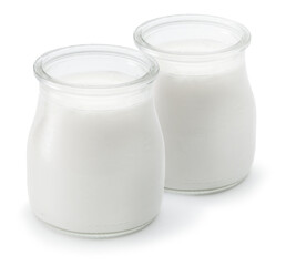 Two glass containers with plain yoghurt isolated on white background.