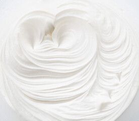 Waves and swirls in creamy yoghurt or cream surface. Top view.