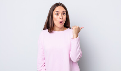 hispanic pretty woman looking astonished in disbelief, pointing at object on the side and saying...