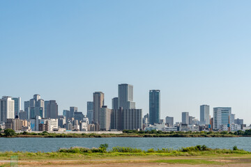 Fototapeta na wymiar View of office buildings of central Osaka city from Yodogawa river bank