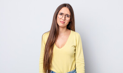 hispanic pretty woman feeling puzzled and confused, with a dumb, stunned expression looking at...