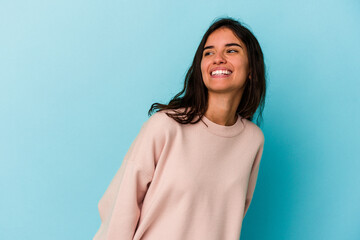Fototapeta premium Young caucasian woman isolated on blue background relaxed and happy laughing, neck stretched showing teeth.