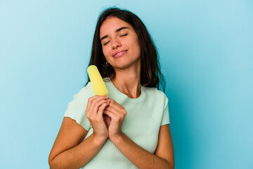 Young caucasian woman holding an ice cream isolated on blue background