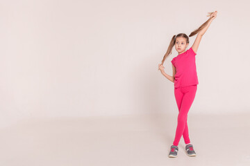 happy child on a white background. a girl in a pink T-shirt and pants.