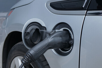 Charging an electric car close up. EV charging port connected to the car