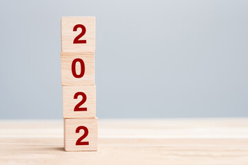 2022 wooden cube blocks on table background. Resolution, plan, review, goal, start and New Year...