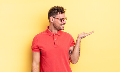 young handsome hispanic man feeling happy and smiling casually, looking to an object or concept...