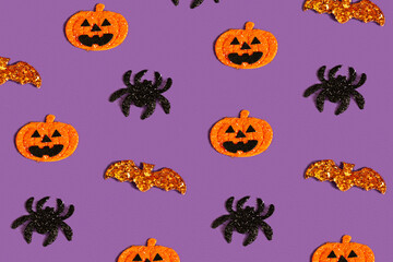 Creative purple pattern made of pumpkin, bat and spiders. Halloween concept. top view, copy space