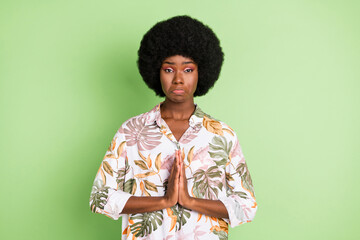 Photo of young black girl unhappy upset ask beg please wish expect wait isolated over green color...