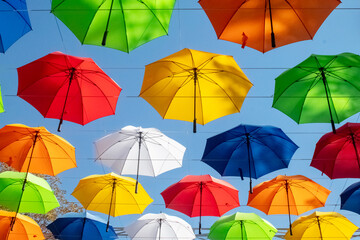 Fototapeta na wymiar Colorful umbrellas. Bottom view. Conceptual art object. No labels or identification marks. Place for your text. Colorful background. Concept of a good mood and protection from problems. Sky is visible