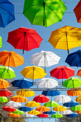 Fototapeta na wymiar Colorful umbrellas. Bottom view. Conceptual art object. No labels or identification marks. Place for your text. Colorful background. Concept of a good mood and protection from problems. Sky is visible