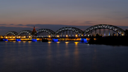 Fototapeta na wymiar Dawn in Riga over the Daugava river against the background of the railway bridge