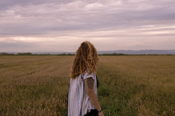 Obraz premium Woman in a shirt walking through a rice paddy at sunset