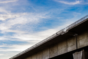 Clean blue sky with scattered clouds over the under construction bridge