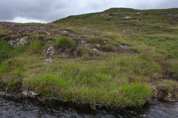 Ireland peet and heather fields. Mountains. Connemara. Small brook and grass.