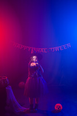 Little girl holds broom on Halloween holiday. Kid girl wear witch costume. Fantasy, fairy tale and masquerade concept.