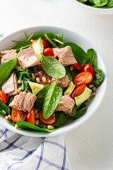 Close up of bowl with tuna fish salad tomato and spinach