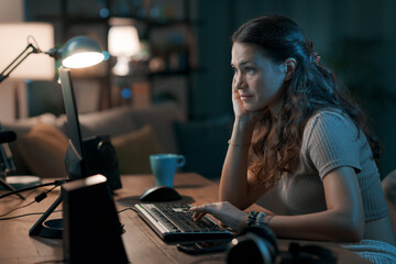 Fototapeta na wymiar Young woman working from home at night