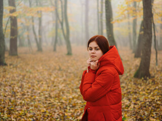 woman in red jacket in autumn forest fog nature fresh air
