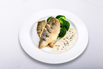 Tasty fish dish in sauce on plate