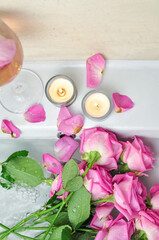 Glass of wine and bouquet of pink roses in sink