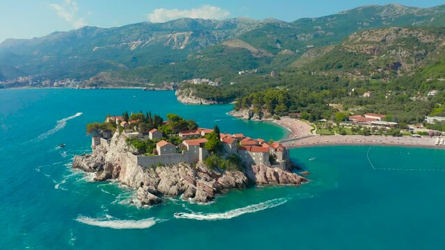Famous Sveti Stefan island in Budva during a beautiful summer day, Montenegro. Aerial drone view 4K.