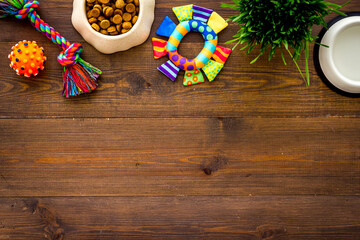 Dry dog food in bowl with toys and treats, top view