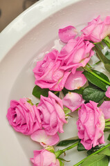 Glass of wine and bouquet of pink roses in sink