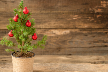 Christmas tree with Christmas ornaments on wooden background