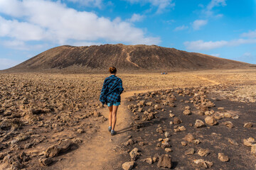 A young woman on the trail to the Crater of the Calderon Hondo volcano near Corralejo, north coast...