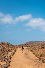 Fototapeta na wymiar A young woman visiting the Isla de Lobos, along the north coast of the island of Fuerteventura, Canary Islands. Spain