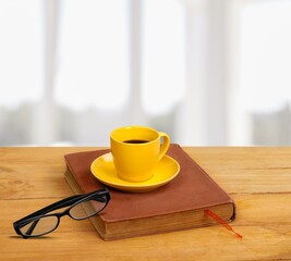 A coffee cup and book on wooden table. Back to school concept