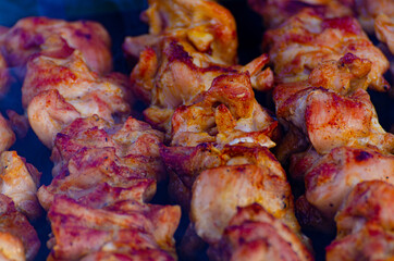 Ready fried delicious juicy shish kebab on skewers lies on the grill in the light smoke of the fire