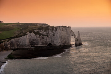 Beach and cliffs during sunset in the town of Etretat in Normandy, France