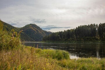 Autumn landscape. A winding river flows out of a mountainous area.