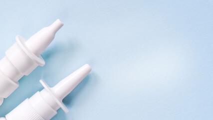 2 white nasal sprays on a light blue background. The concept of autumn diseases, allergies. - obrazy, fototapety, plakaty