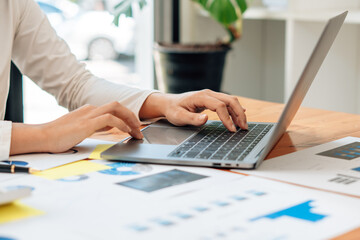 Close up of businessman or accountant working on laptop computer for calculate business data,...