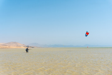Children learning Kitesurfing or sky surfing on Sotavento beach in the south of Fuerteventura, Canary Islands. Spain