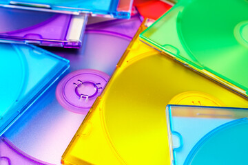 Close-up of multi-colored cd cases - abstract pattern in yellow, green, red, blue, purple.