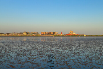 Low tide during the sunset in Buesum, North sea - Germany. View to the light house.