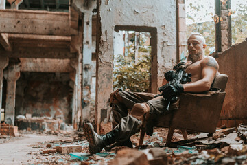 Fototapeta na wymiar a man in a military uniform with a machine gun in an old destroyed building